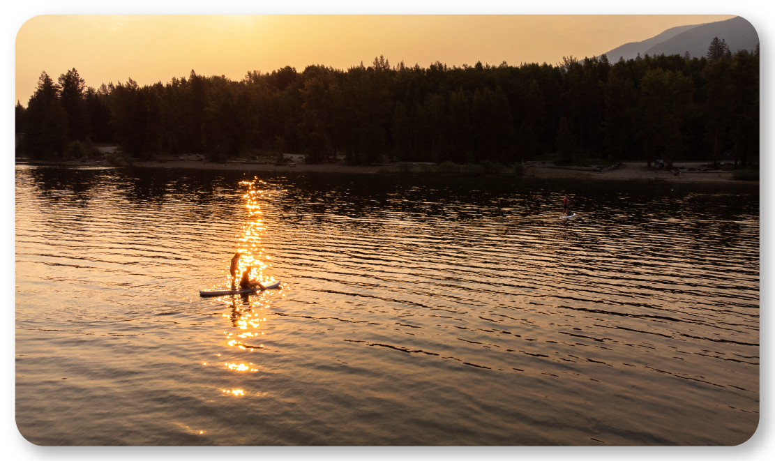 lake at sunrise with paddleboarder
